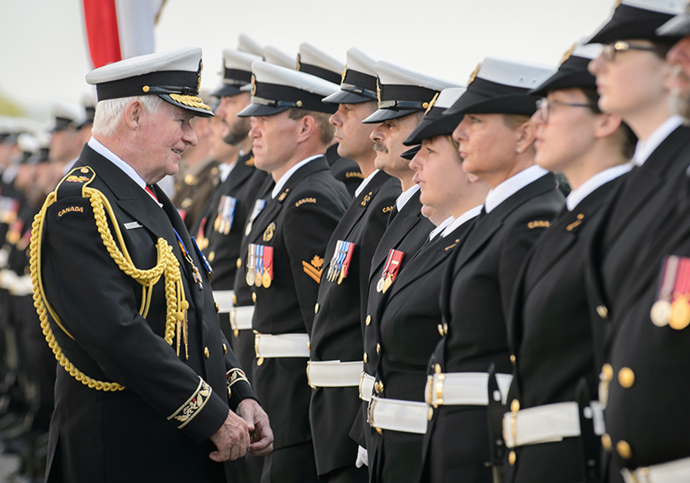 Former veteran smiling towards a line of current soldiers